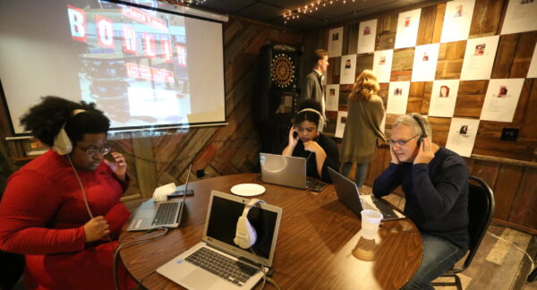 a group of students seated at a table with open laptops