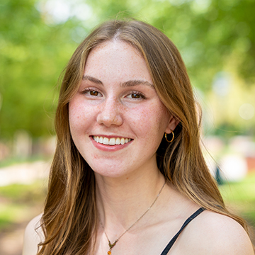 a woman with long straight hair smiling at camera