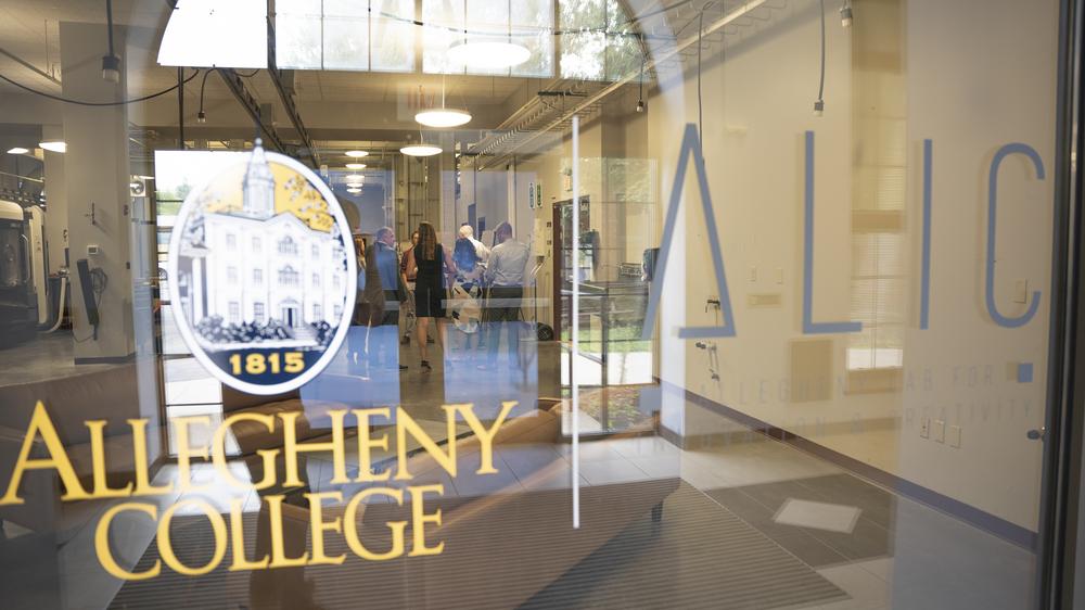 view through a glass window with logos on the glass and blurry people visible within the room