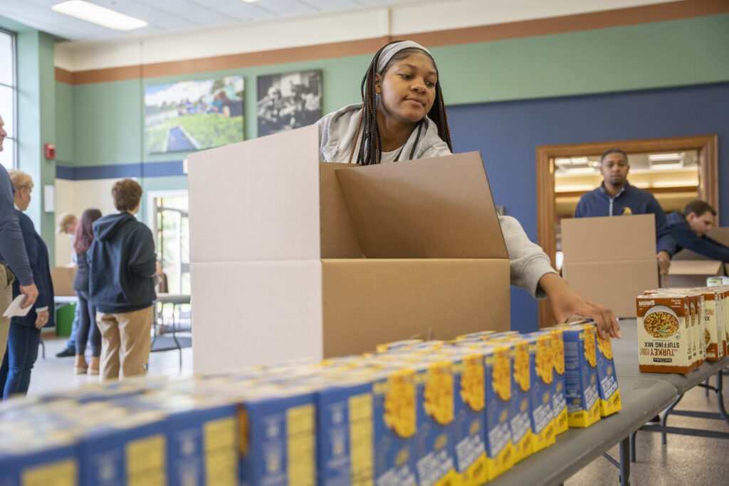Student packing macaroni for the food dirve