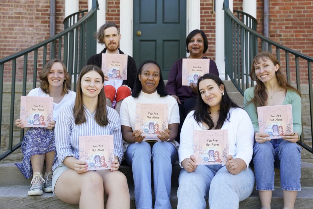 a group of students sitting on steps holding books