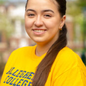 Woman with side ponytail wearing yellow Allegheny College shirt