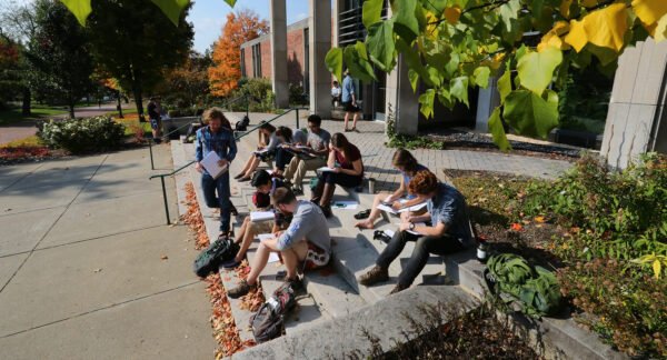 a group of students sitting on steps outside