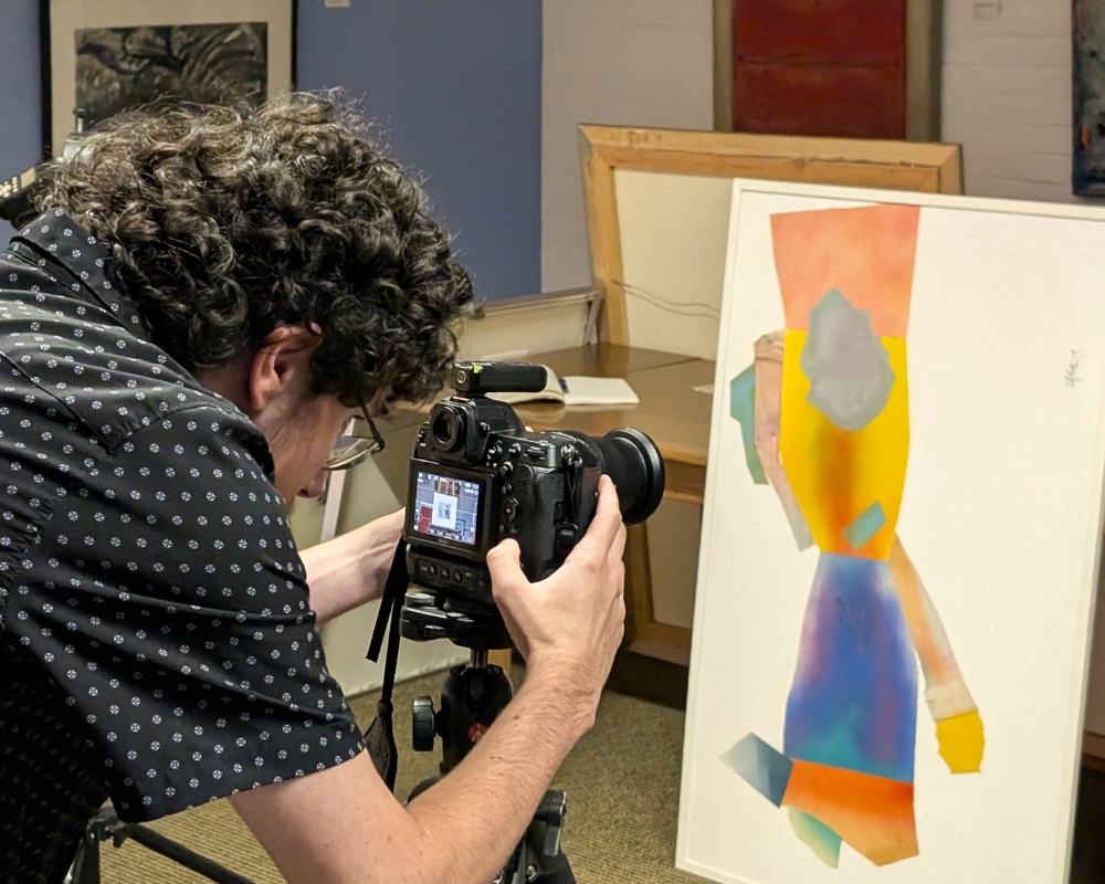 Allegheny College student checks a photo on a digital camera for visual imperfections