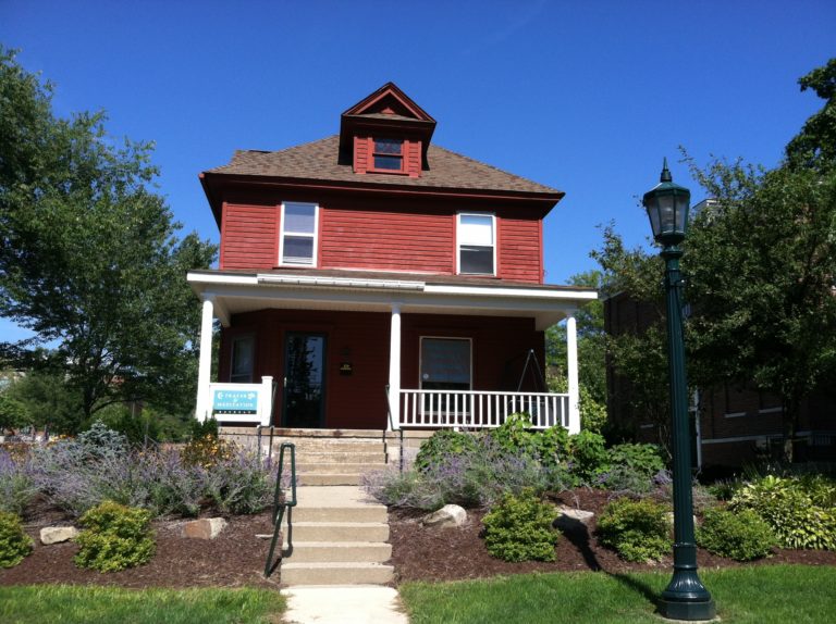 a red house with a porch and stairs