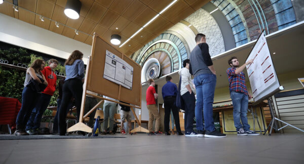 a group of students standing in a room looking at bulletin boards