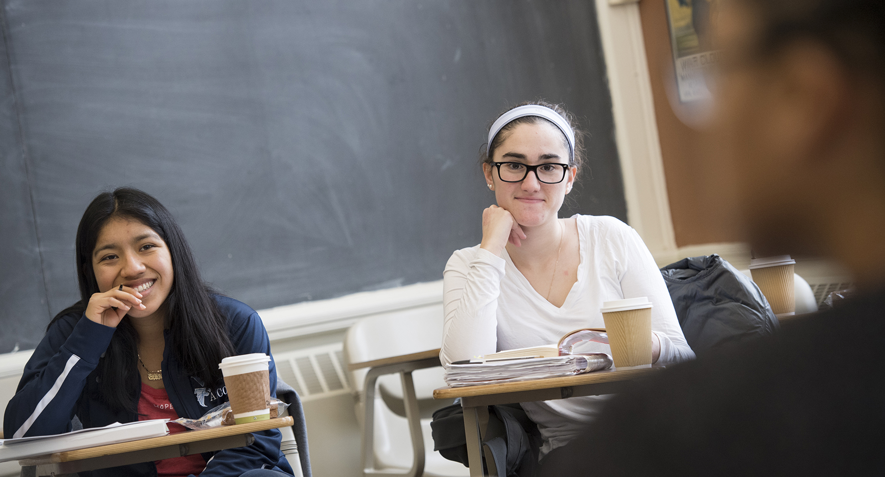 a student sitting at a desk with her hand on her chin