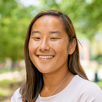 a person smiling with trees in the background