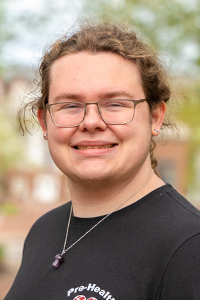 Smiling man with hair pulled back wearing black shirt