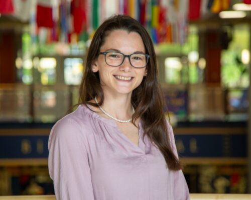 Headshot of Hope Dixon with Allegheny College's Gallery of Flags in the background
