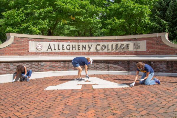 people in front of an Allegheny College sign