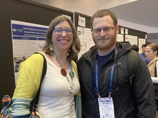 Lisa Whitenack and Anthony Hessel ’12 standing in front of poster presentations
