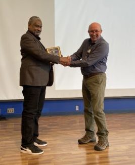 two men shaking hands on a stage