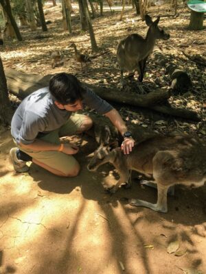 a person kneeling down with a kangaroo