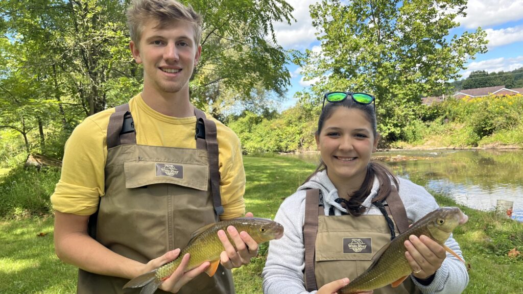 Students pose with caught fish after a day of aquatic sampling