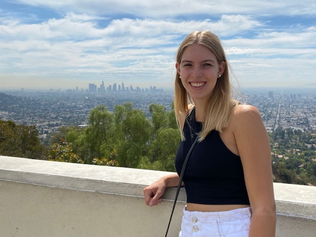 a person standing on a ledge with a city in the background