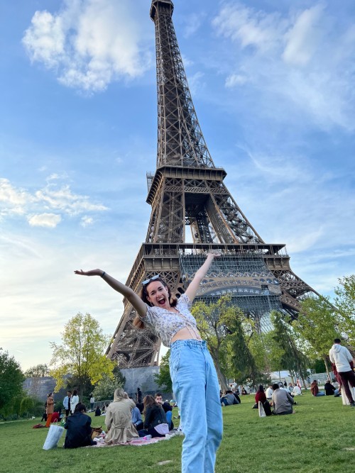 a person posing in front of the Eiffel Tower