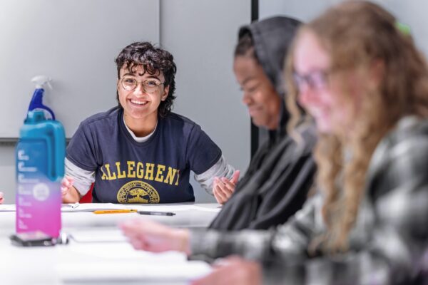 Allegheny College students sit at white seminar tables in a classroom