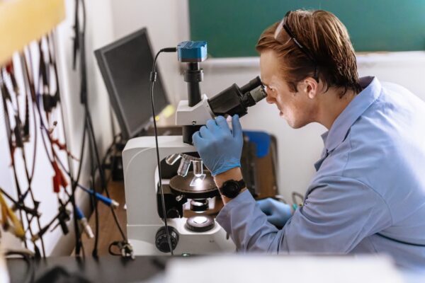 An Allegheny College student looks through a microscope.