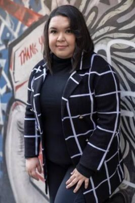 portrait of a person standing in front of an outdoor wall