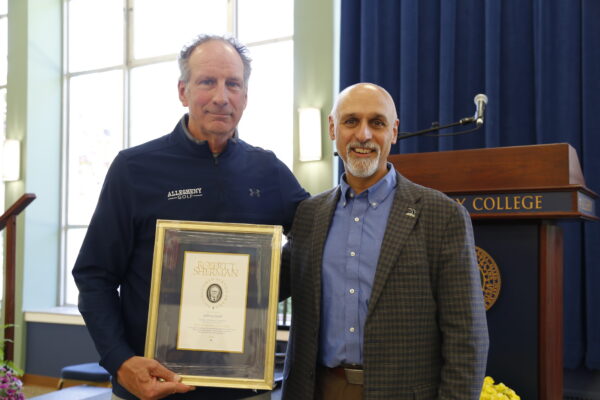 Coach Groff holding an award with President Cole 
