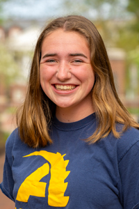 Smiling woman with long hair parted in middle