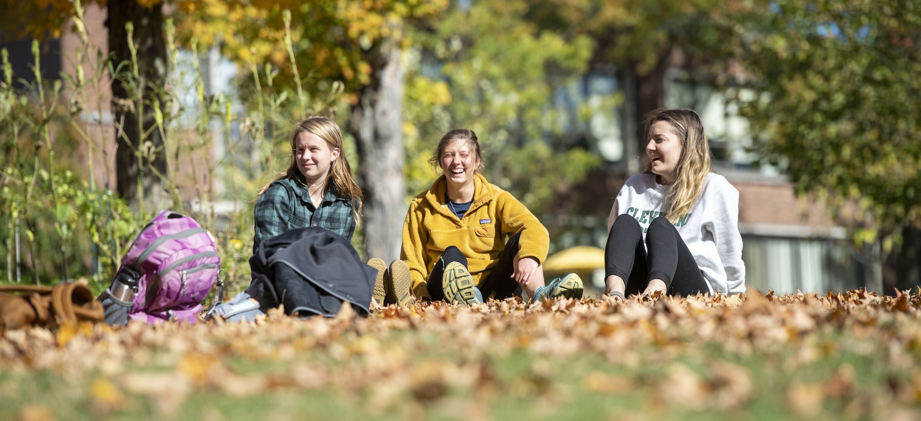 Three students sitting and laughing