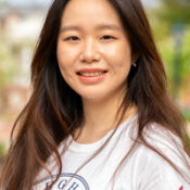 Headshot of smiling woman with long dark hair standing outdoors