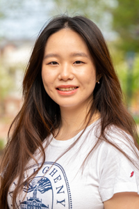 Headshot of smiling woman with long dark hair standing outdoors