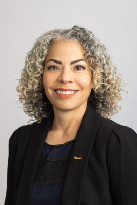 portrait of a person with curly hair smiling