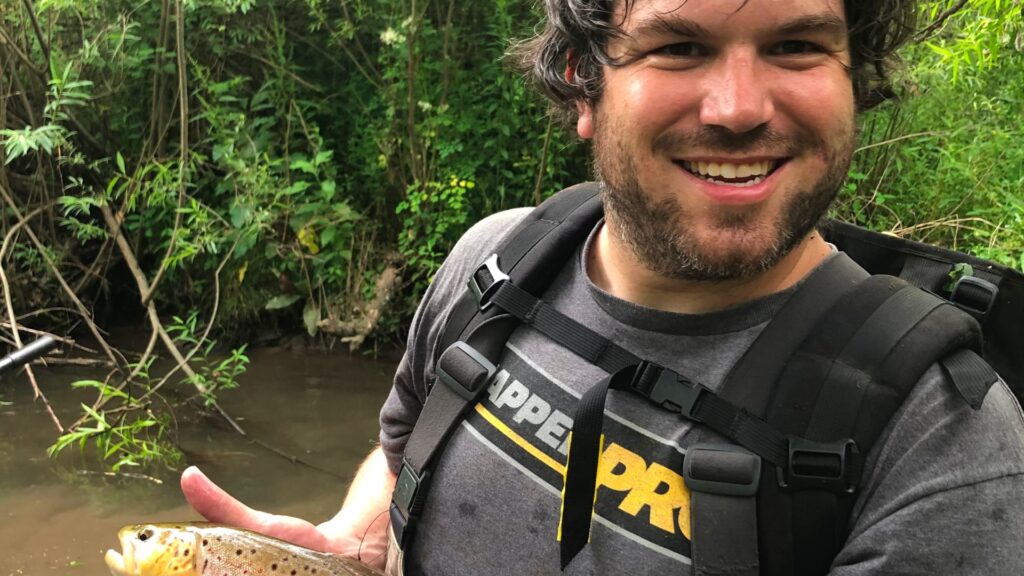 Dr. Mark Kirk, holding a brown trout, after a day of electrofishing