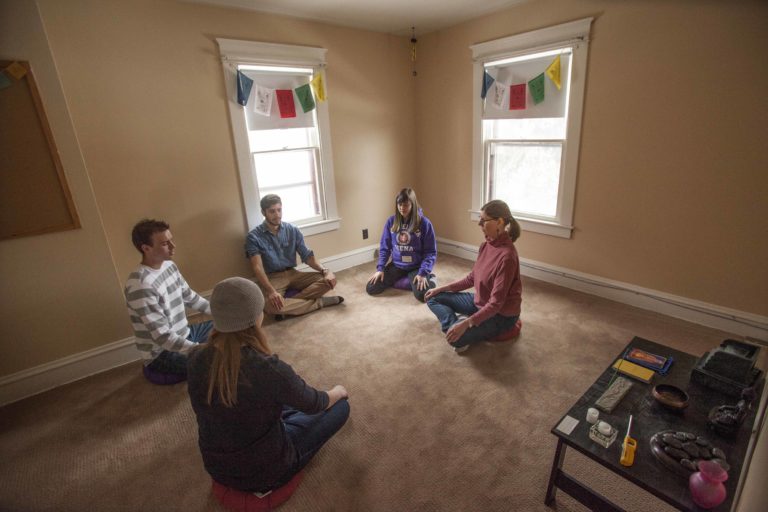 a group of people with legs crossed sitting in a circle