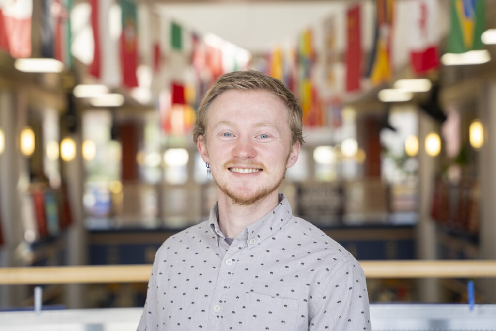 Student smiling with flags in the background
