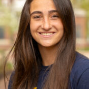 Smiling woman with long dark hair parted in the middle