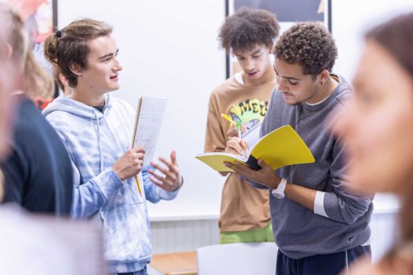 a group of students standing around a table in a classroom