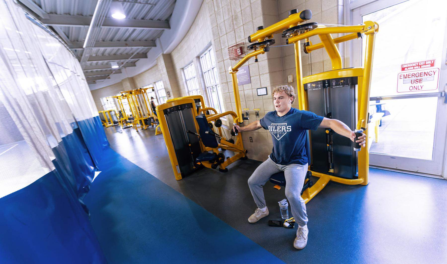 Male student using a fitness machine