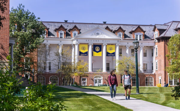 students walking down path on campus in front of historic building