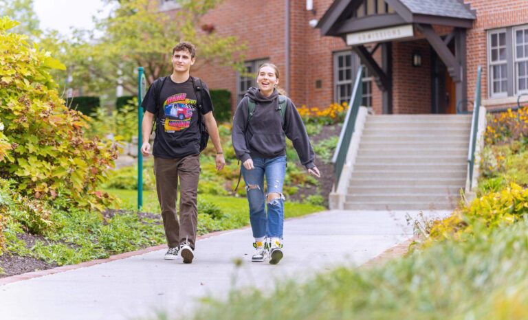 two students walking on a sidewalk