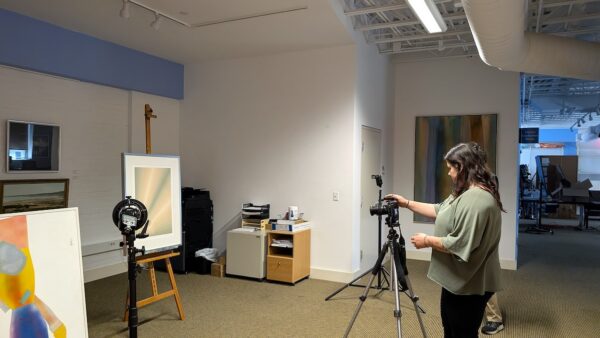 Allegheny College student takes a photo of art in the Erie Art Museum.