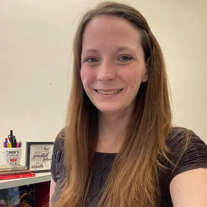 a woman with long brown hair smiling for a selfie