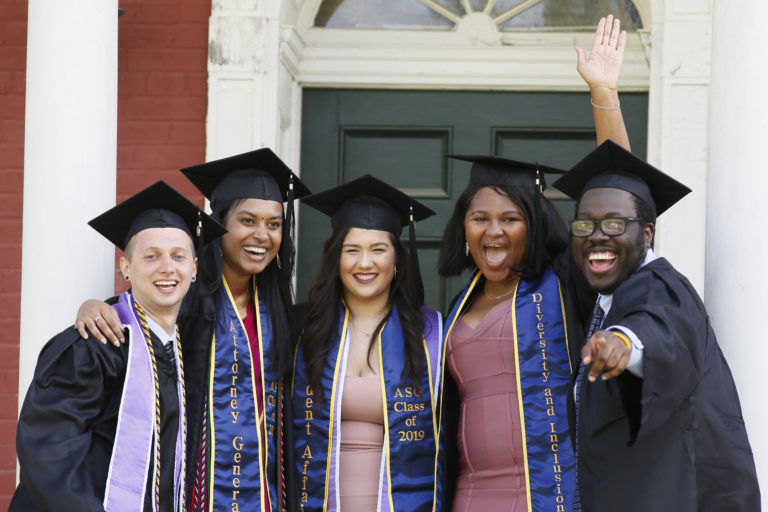 a group of smiling students in graduation gowns and caps