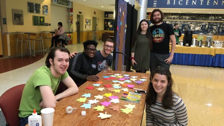 a group of students posing for a photo around a table with paper stars