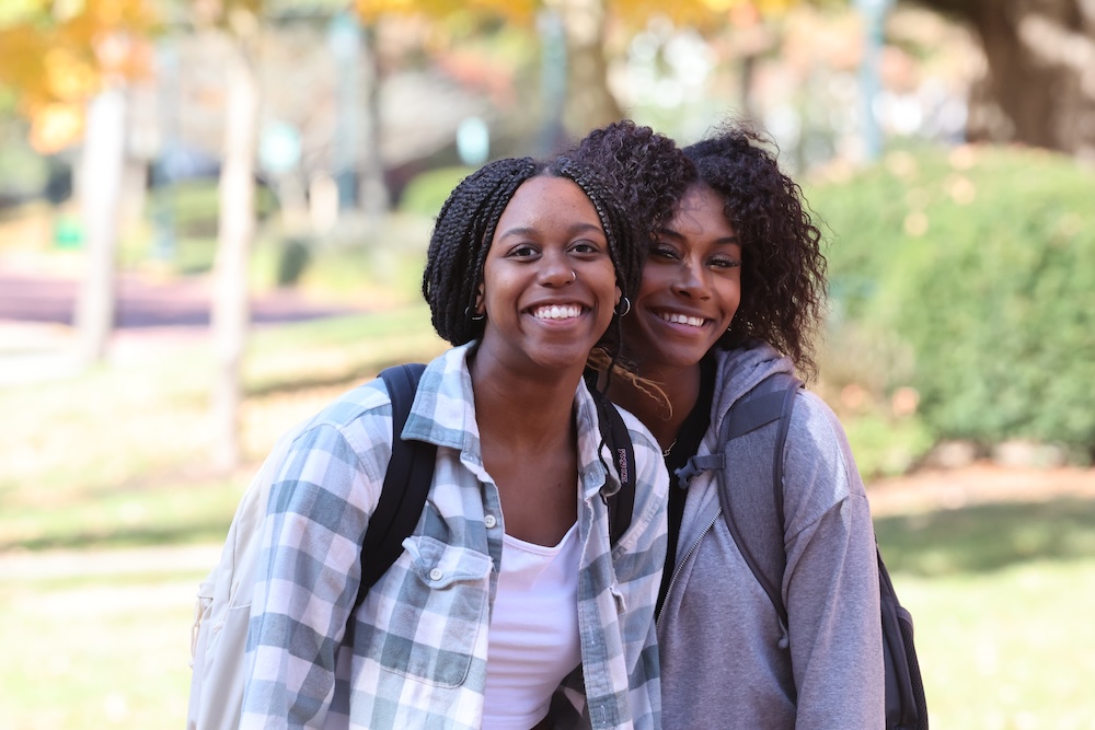 Two Allegheny College students stand next to each other and smile