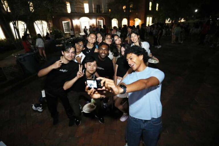 Students taking a selfie outside at nighttime.
