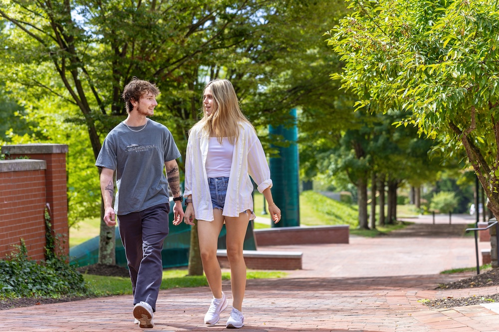 Two Allegheny College students walk away from the Senior Circle sidewalk