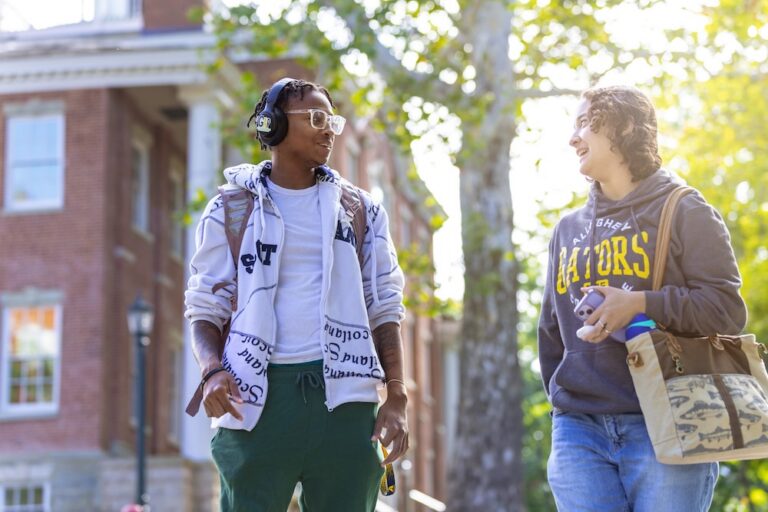 Two Allegheny College students stand outside of Bentley Hall and chat