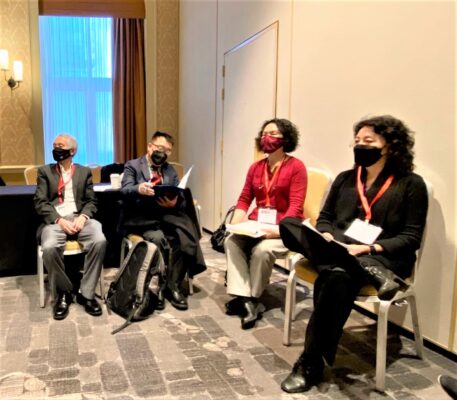 a group of people sitting in chairs wearing face masks