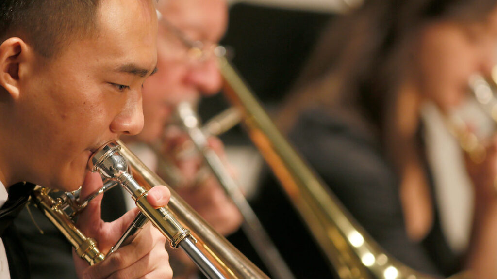 a close-up of a student playing a trumpet