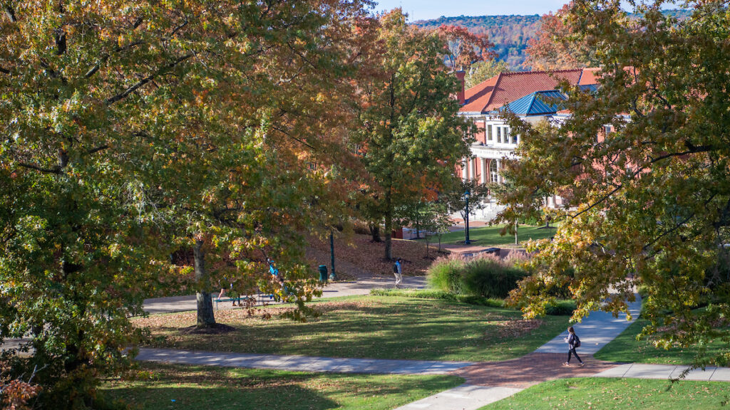 a walking path with trees and a building in the background