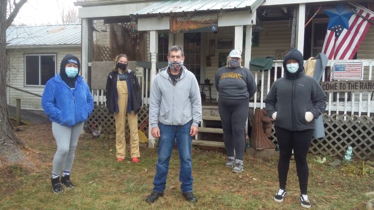 several students standing in front of a house